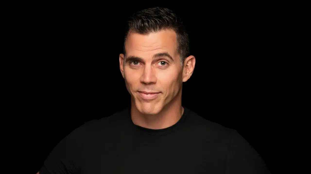 BLACK BACKDROP WITH A MAN LOOKING AT THE CAMERA