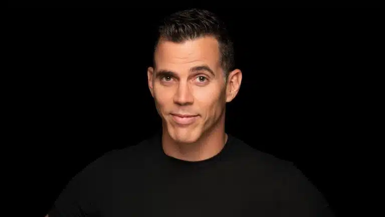 BLACK BACKDROP WITH A MAN LOOKING AT THE CAMERA