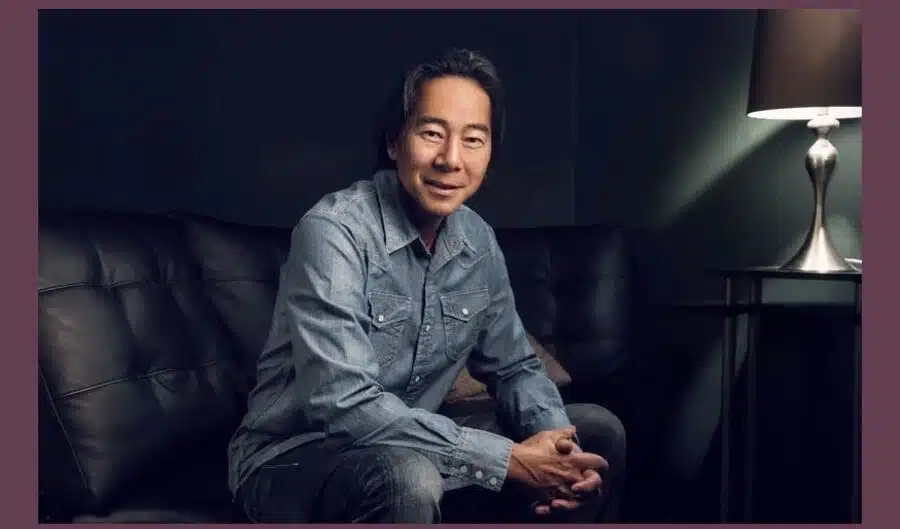 photo of comedian sitting down with black background