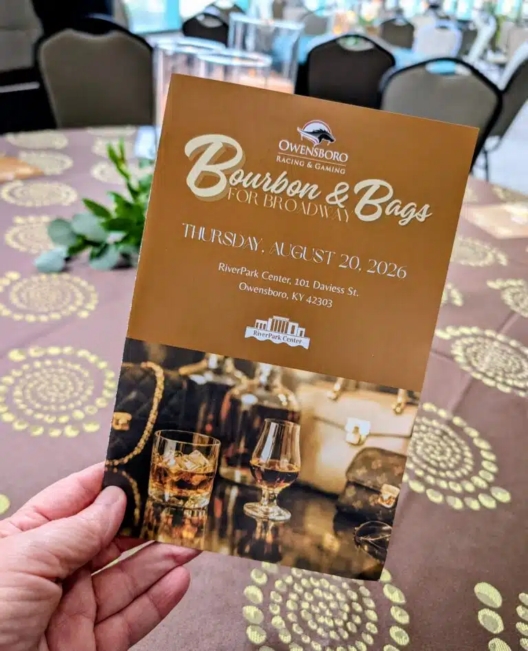hand holding an event program for the Bourbon & Bags for Broadway event