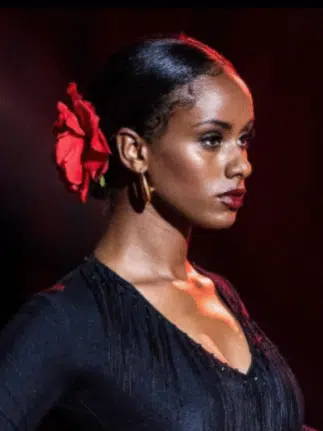 Woman wearing black with a red flower in her hair