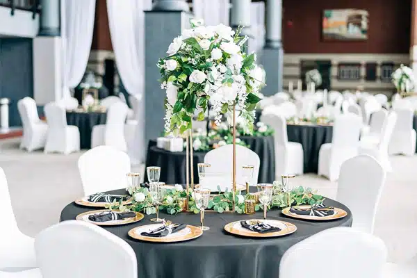 green and white themed floral centerpiece table set up for a wedding reception in the lobby