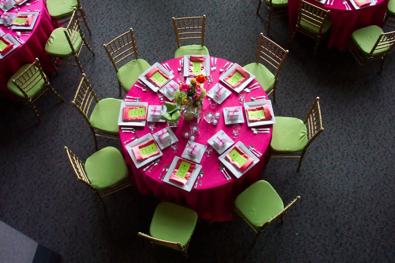 A pink and green themed table setting for a wedding in the lobby of the RiverPark Center