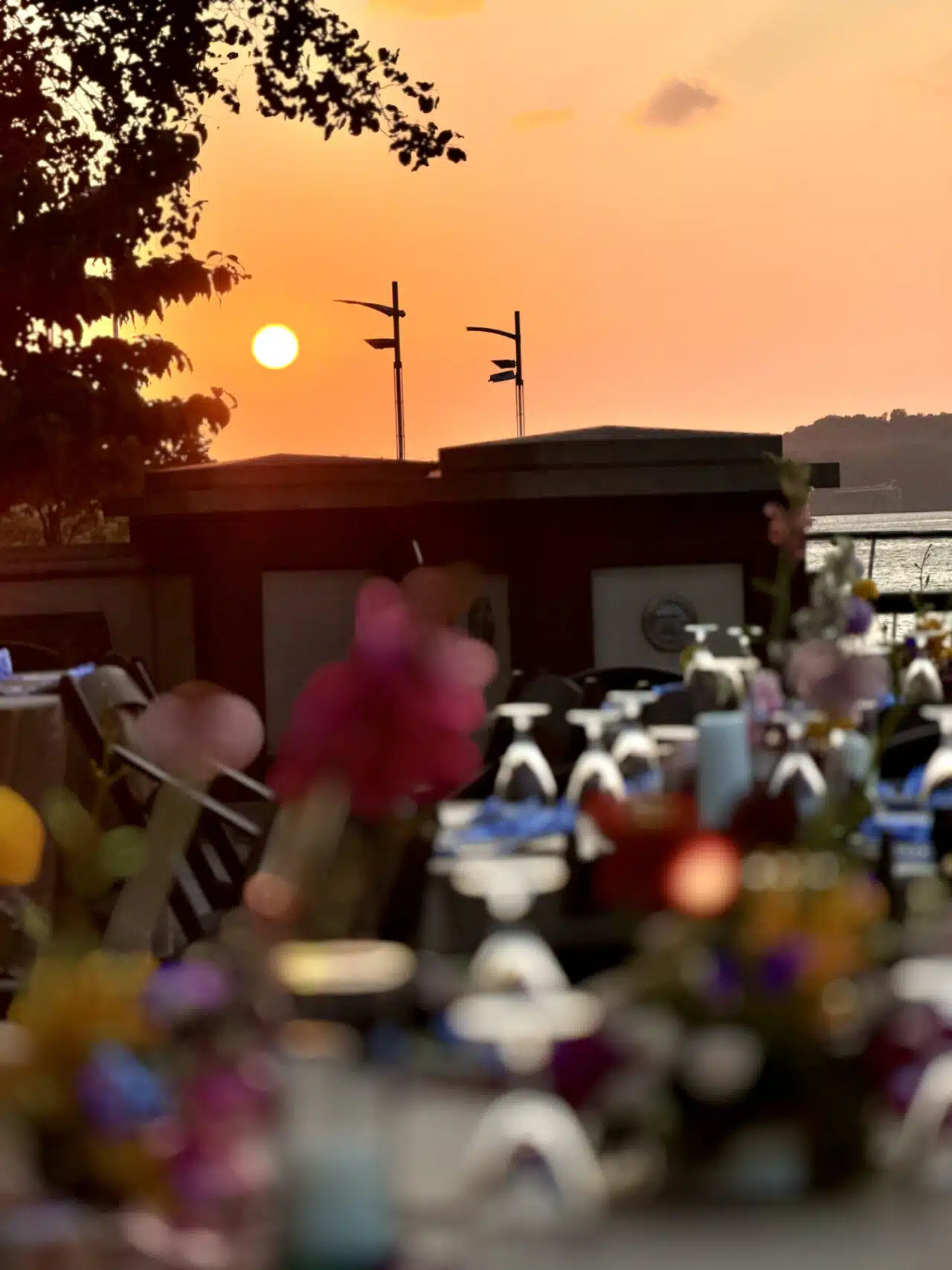 Spectacular orange sky at sunset from the RiverPark Center patio, with a table setting in foreground